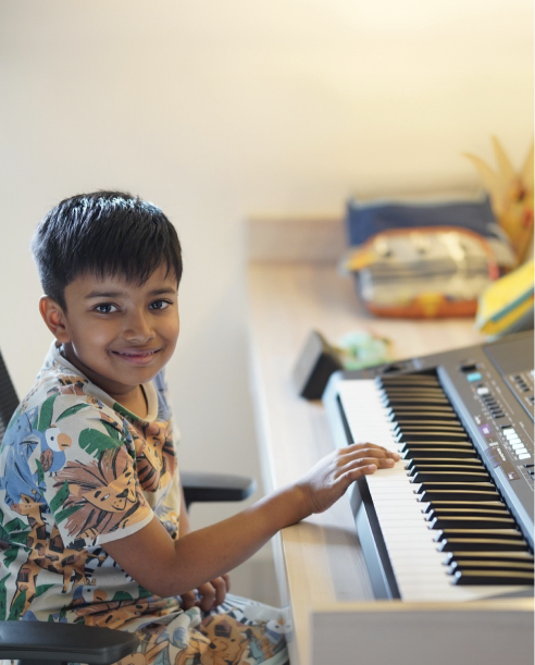 Young pianist smiling at the keyboard